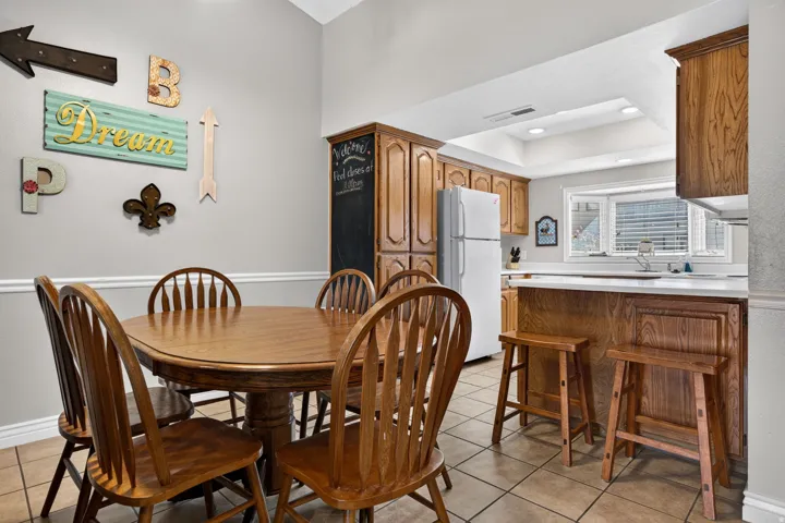 Kitchen featuring wood-finish cabinetry, white countertops, tile flooring, and a bay window