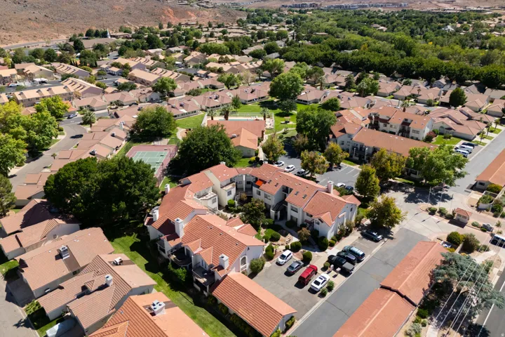 Community with terracotta-style roofs, mature landscaping, and an on-site tennis court