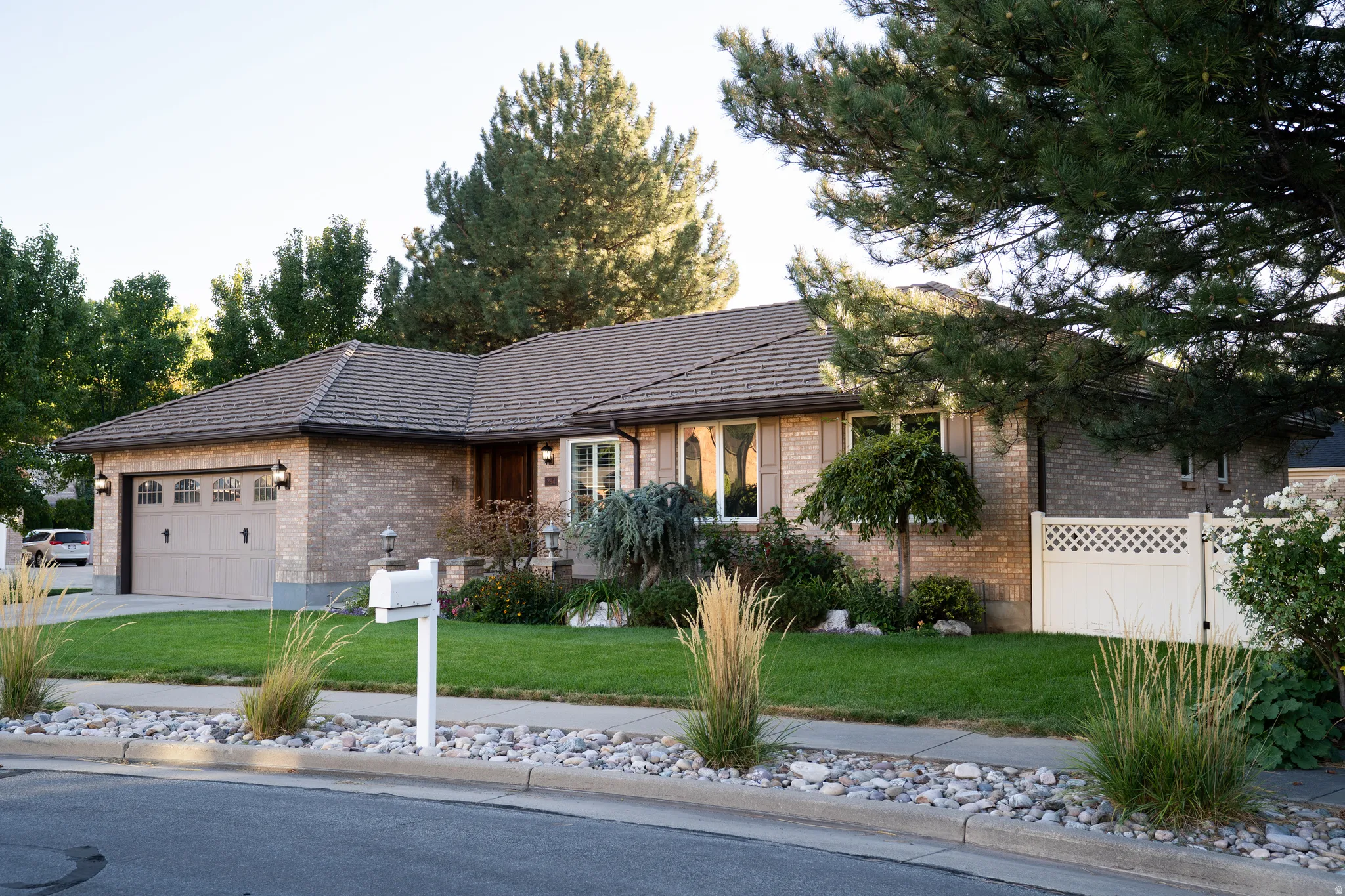 Brick exterior with a multi-pane garage door and decorative exterior lighting