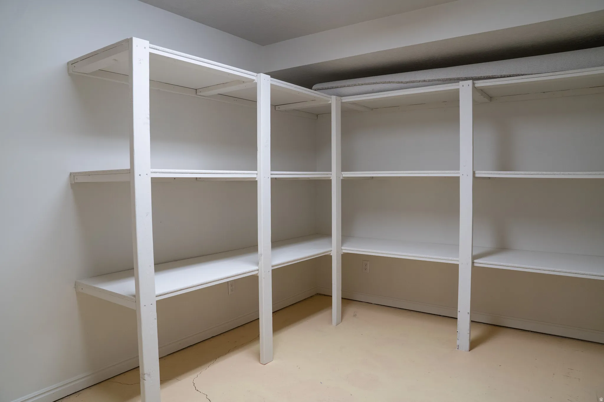 Built-in shelving with multiple levels, white painted finish, and integrated into a corner configuration