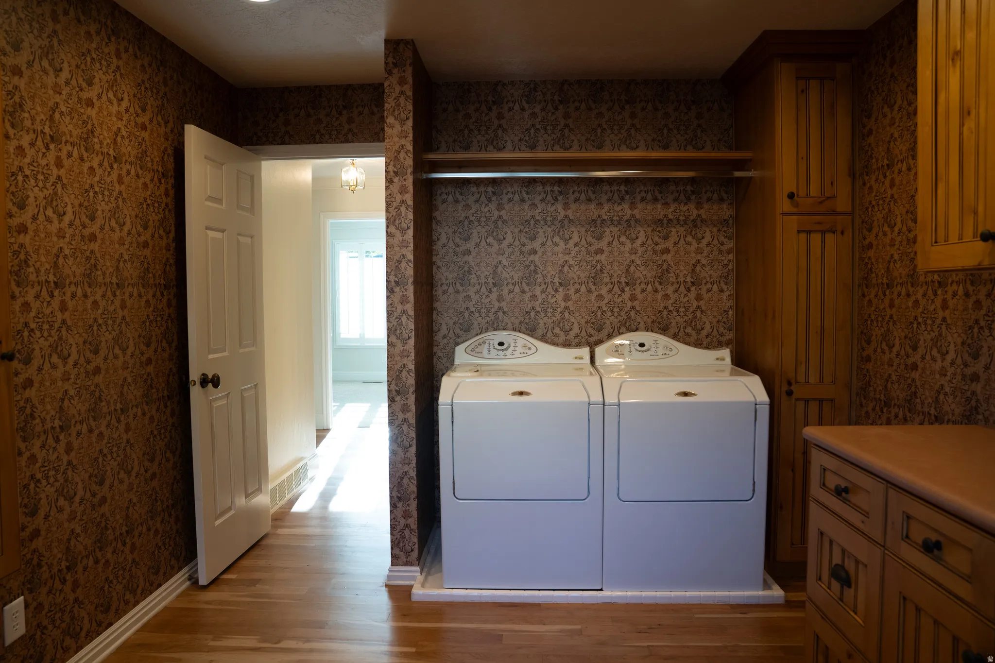 Hardwood flooring, custom wood cabinetry, built-in storage, and clothes rack