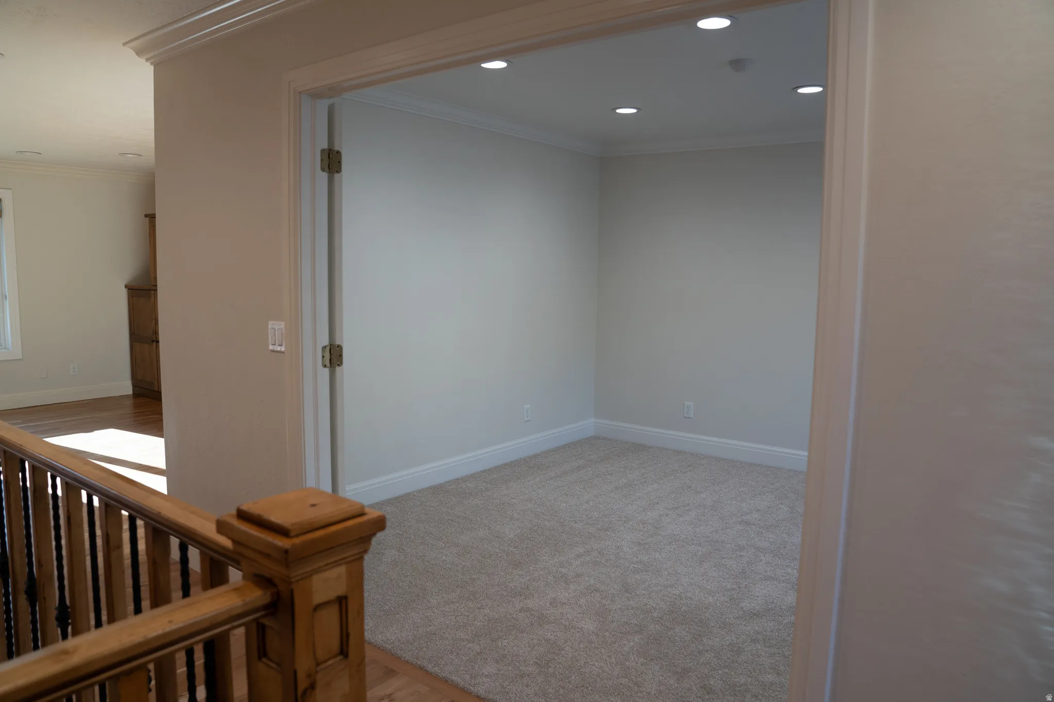 Carpeted room with recessed lighting, crown molding, and baseboards