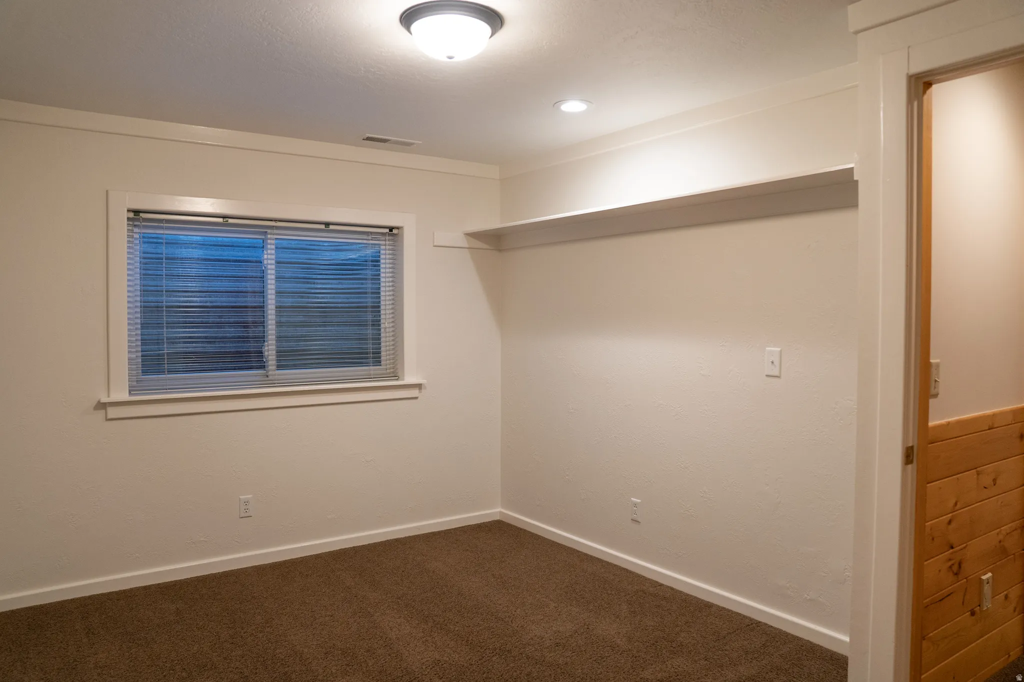 Carpeted flooring, recessed lighting, built-in shelving, white trim, and a window with blinds