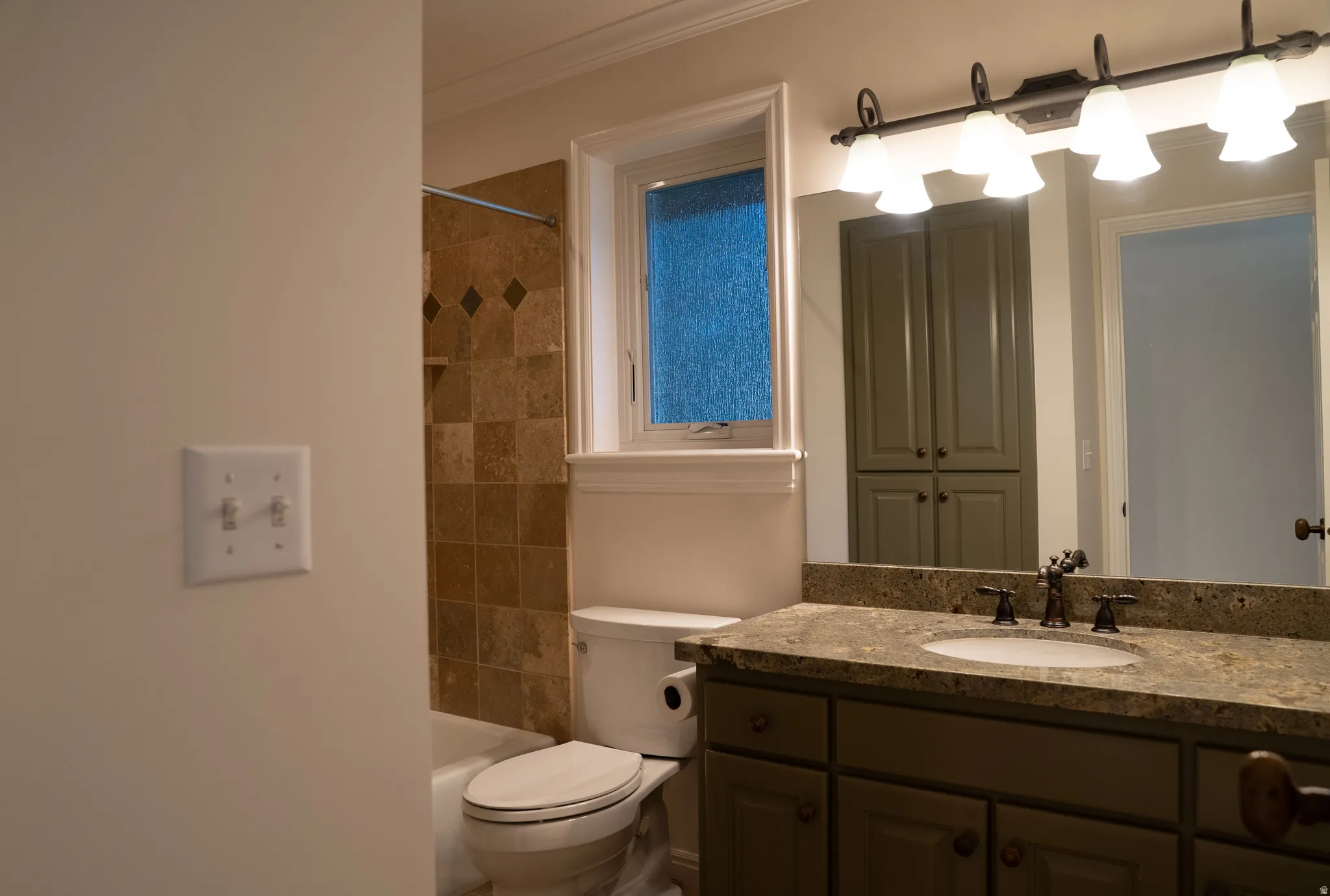 Bathroom vanity with a surface-mounted sink, a multi-light fixture, and a built-in linen cabinet