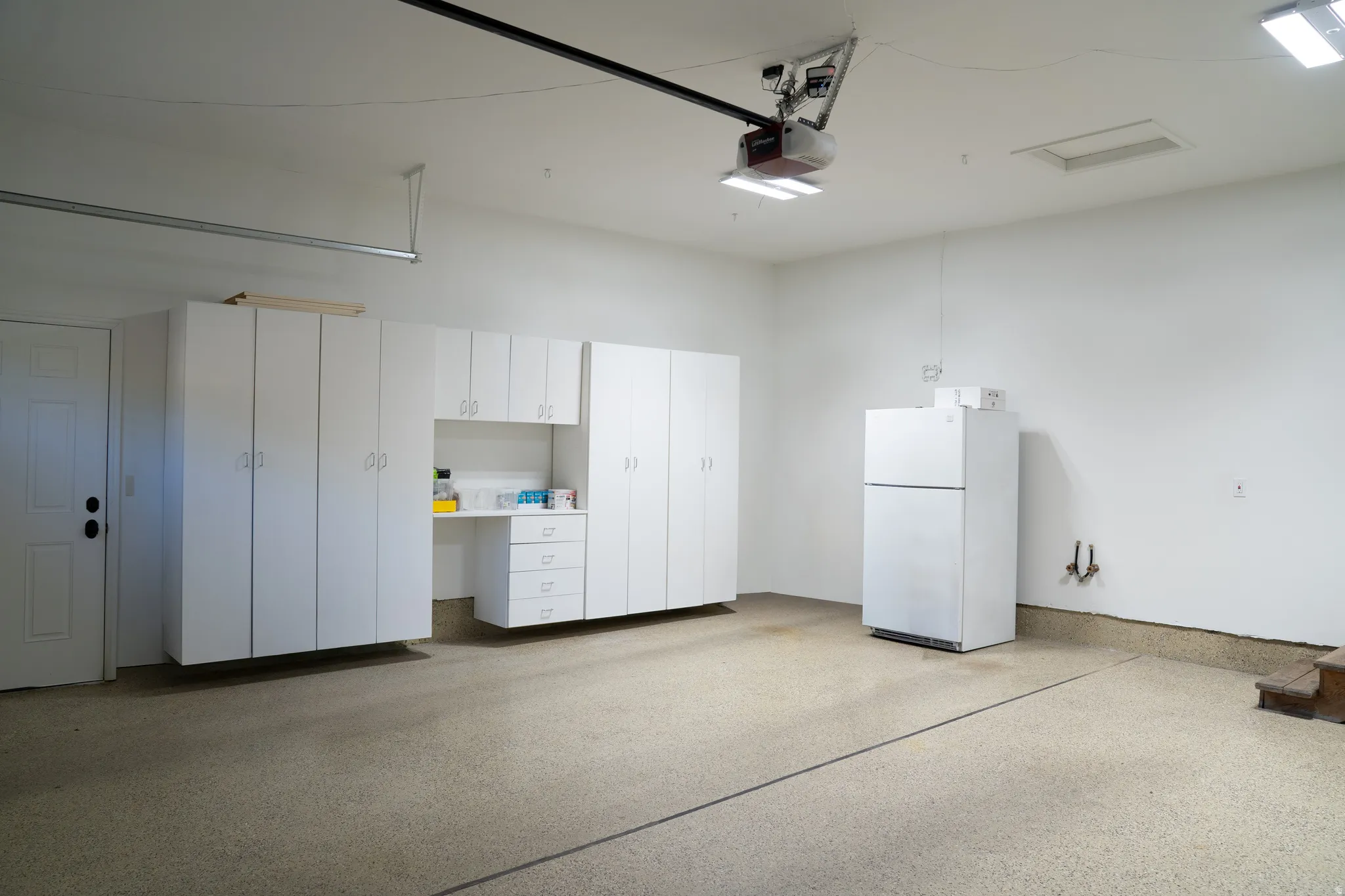 Built-in white cabinetry, integrated desk area, and durable epoxy flooring
