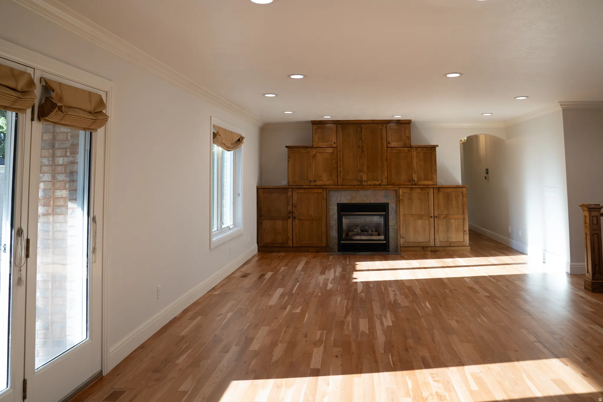 Hardwood flooring, recessed lighting, built-in cabinetry, fireplace, and crown molding