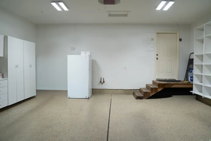 Epoxy-coated flooring, built-in storage cabinetry, fluorescent overhead lighting, and built-in shelving