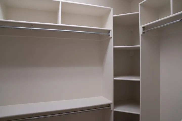 Custom closet system with multiple shelving units and integrated hanging rods