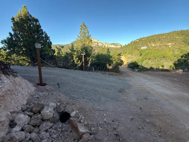 Extensive gravel driveway leading to a treed landscape with a mountain backdrop