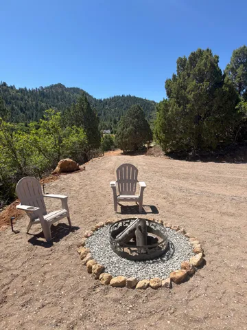 Outdoor fire pit with a decorative metal ring, gravel surround, and stone border