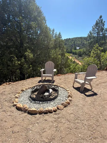 Outdoor fire pit featuring a rock border and gravel base