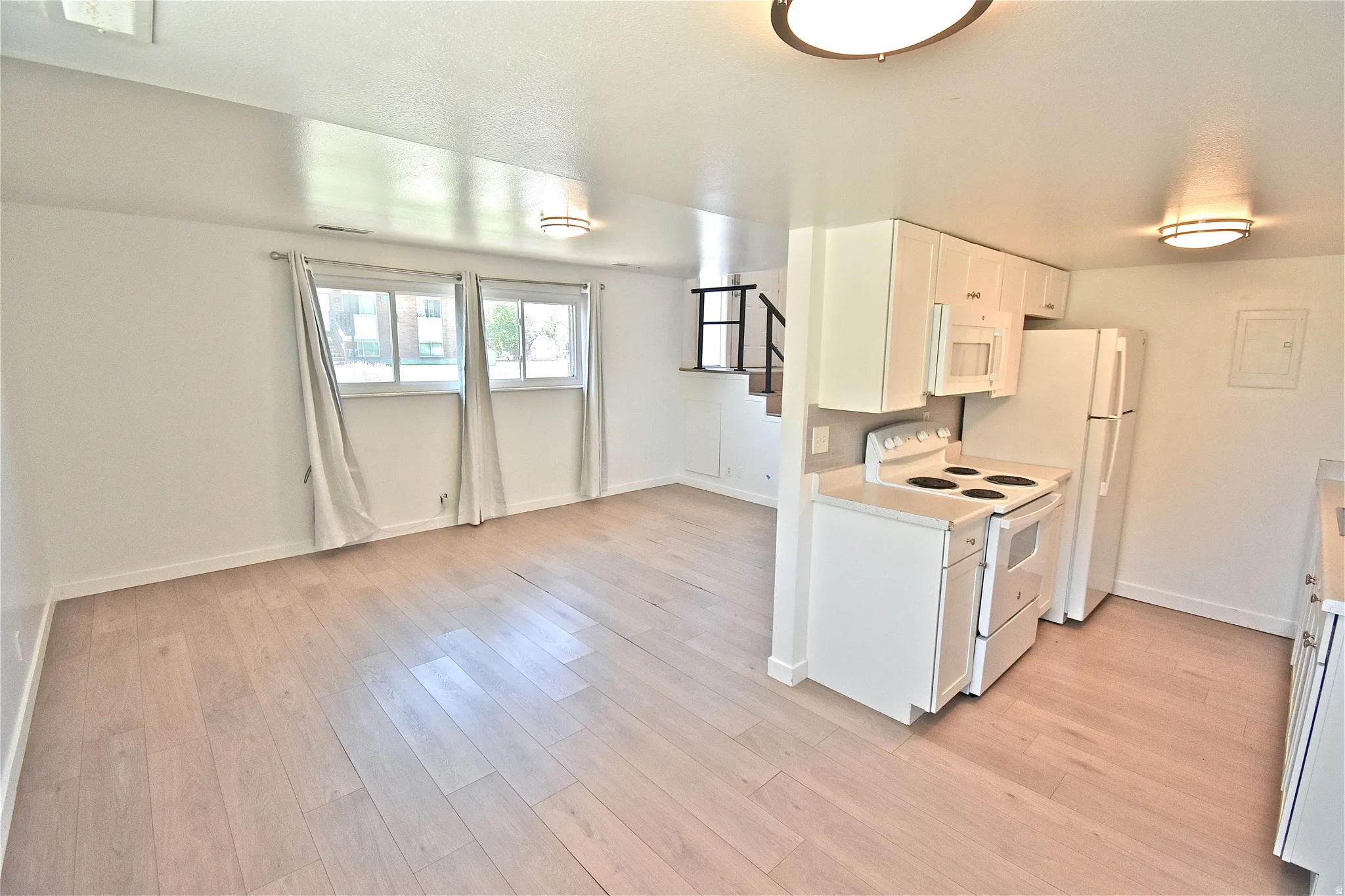 Living room opens to the kitchen, with stairs up to the bedroom level