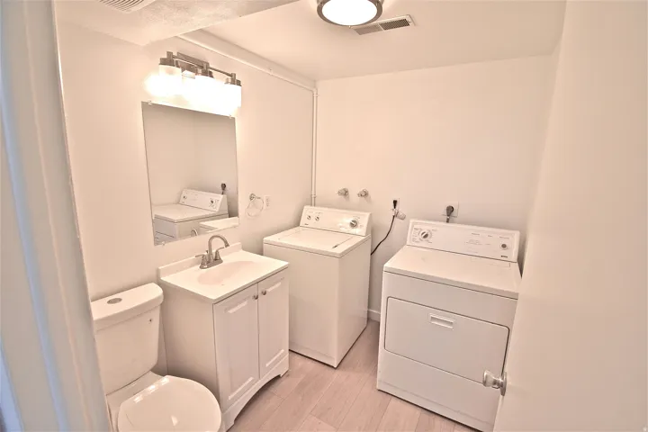Main-level half bath with washer and dryer hookups (machines shown are not included)