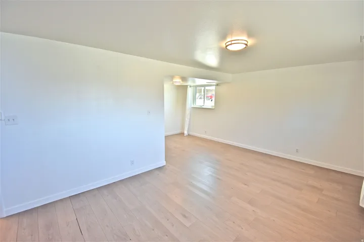 Living room with LVP flooring and fresh paint. All interior photos are unit 1026; all four units received the same 2022 finishes