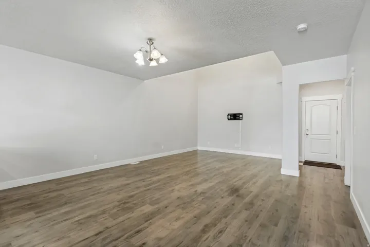 Spacious interior featuring wood-finish flooring, white walls, and a ceiling-mounted light fixture