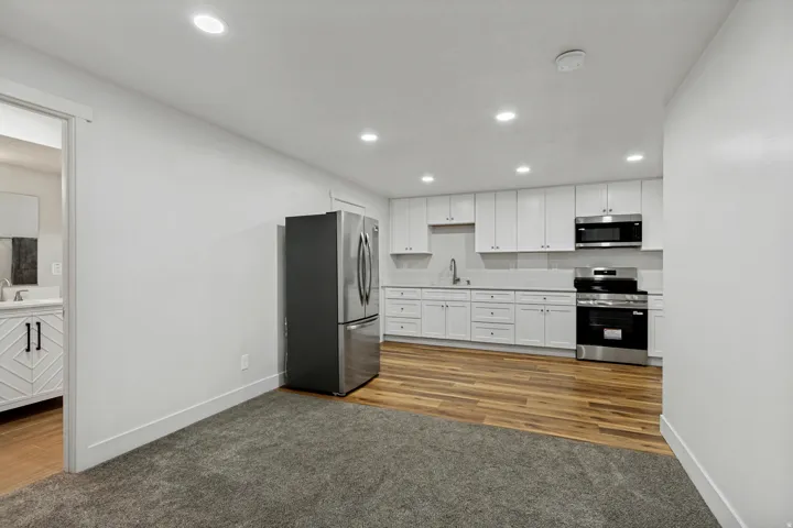 Full kitchen with white cabinetry, stainless steel appliances, and a solid-surface countertop