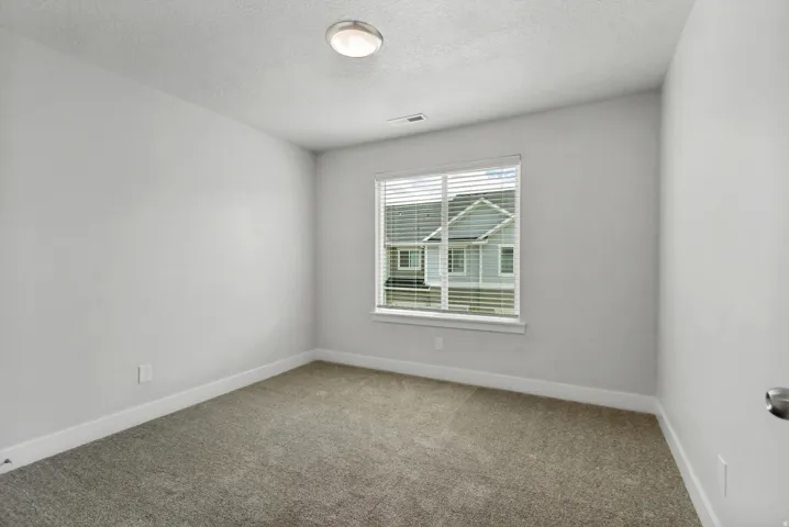 Neutral wall paint, window with blinds, carpeted flooring, and flush-mount ceiling light