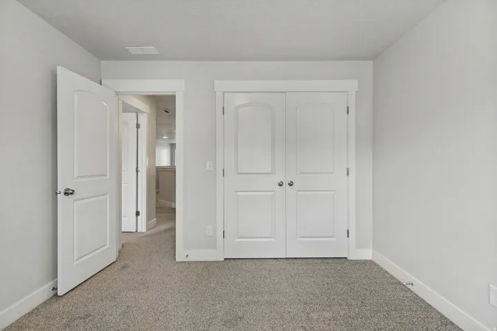 Light gray wall finishes, white trim, and gray carpet