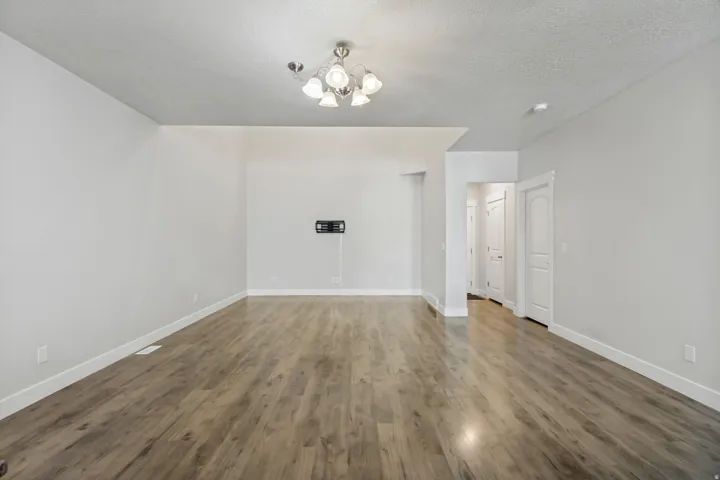 Wood-finish flooring, neutral wall tones, and overhead lighting