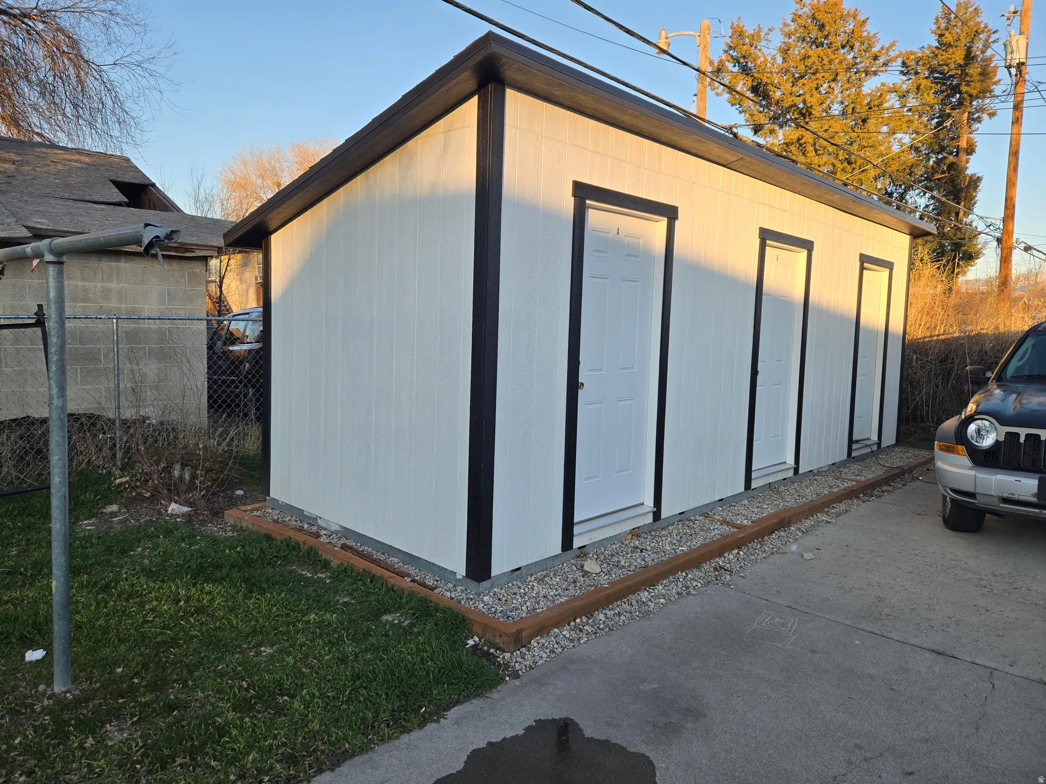 Detached storage building with multiple entry doors and a sloped roof