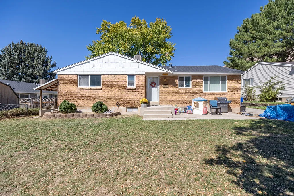Brick exterior home with white trim, a concrete patio, and a covered side entrance