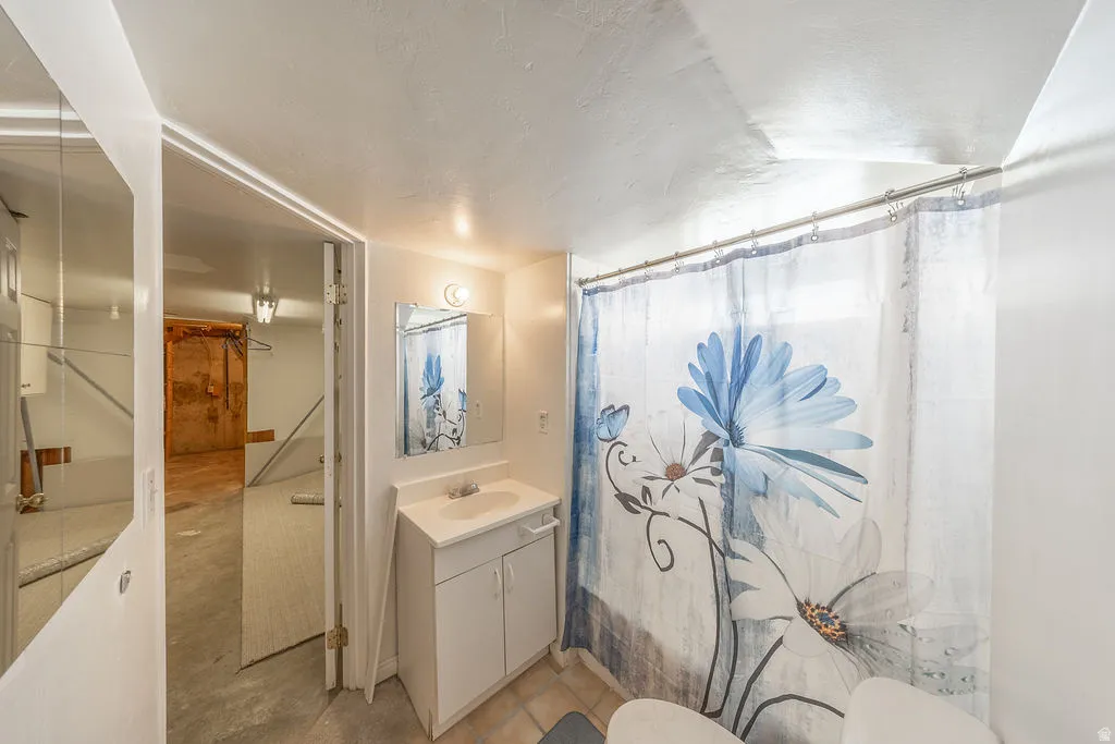 Bathroom featuring a single vanity, basin sink, and an overhead light fixture