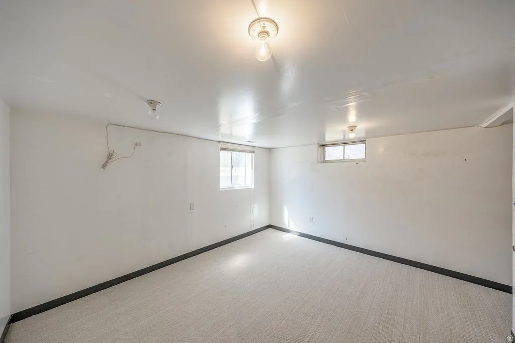 Recessed window, white walls, light-colored carpeting, and ceiling-mounted lighting fixtures