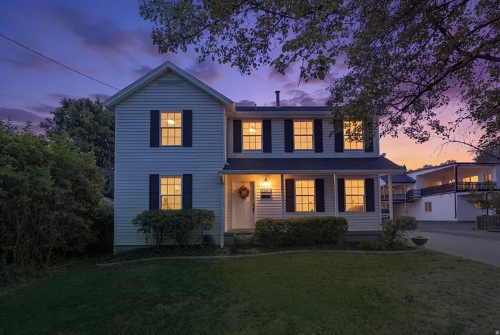 Two-story exterior with siding, a covered entry, and dark window shutters