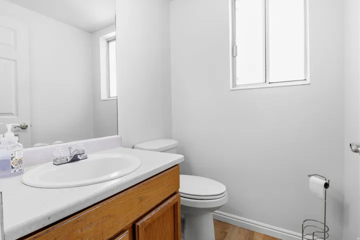 Bathroom featuring a wood-finish vanity with an integrated sink and a window
