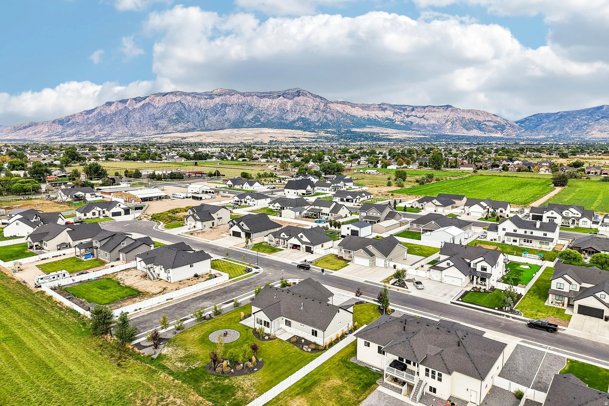 Residential neighborhood with contemporary single-family homes, landscaped yards, paved streets, and expansive mountain scenery