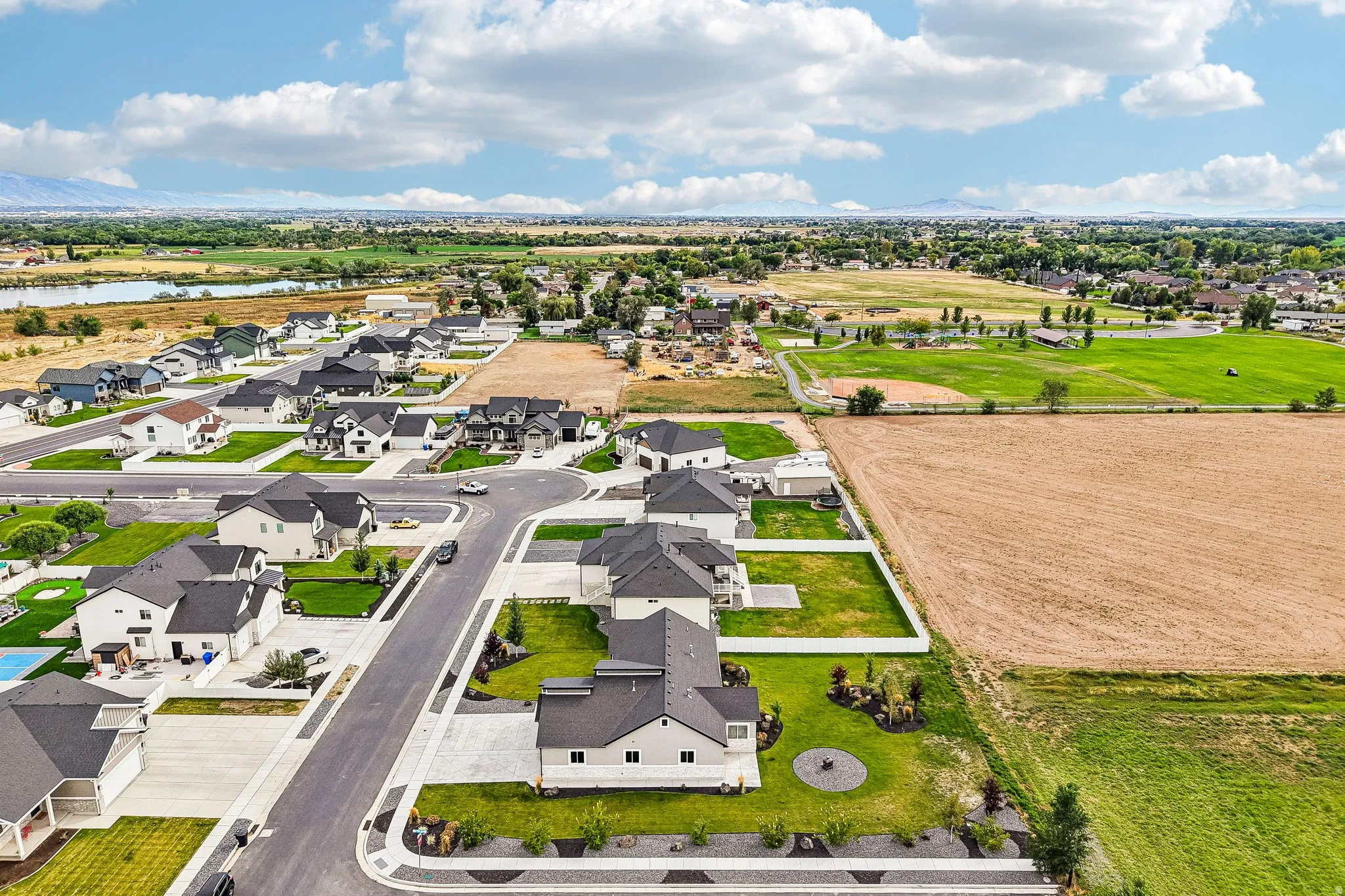 New construction residential development with established landscaping, paved streets, and concrete sidewalks