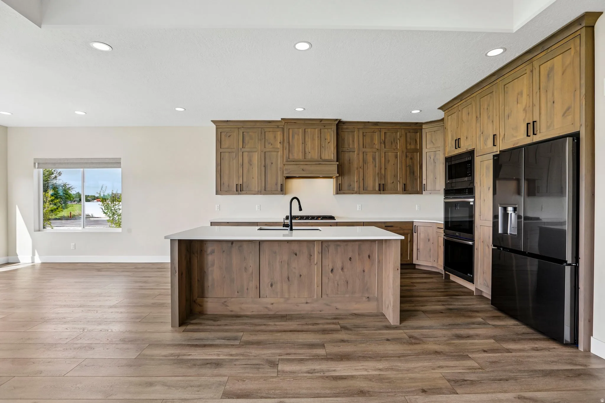 Wood-finish flooring throughout, complemented by light-toned walls and a recessed lighting system
