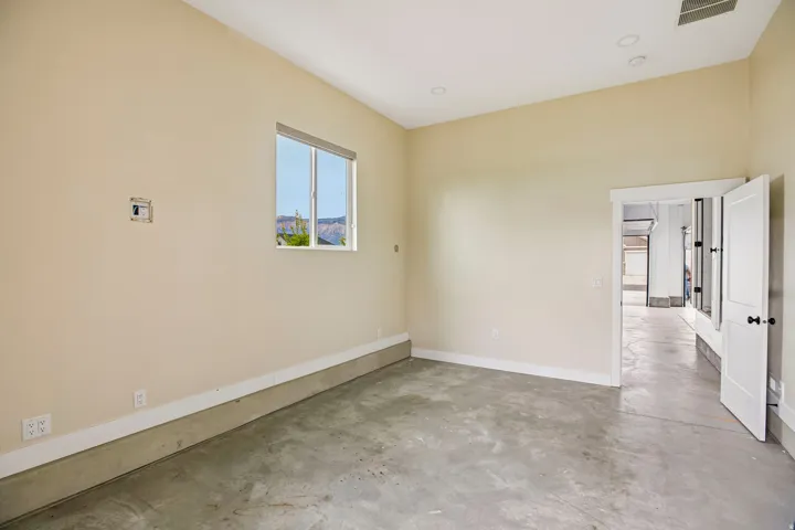 Concrete flooring, high ceilings, recessed lighting, white trim, and a window with a mountain backdrop