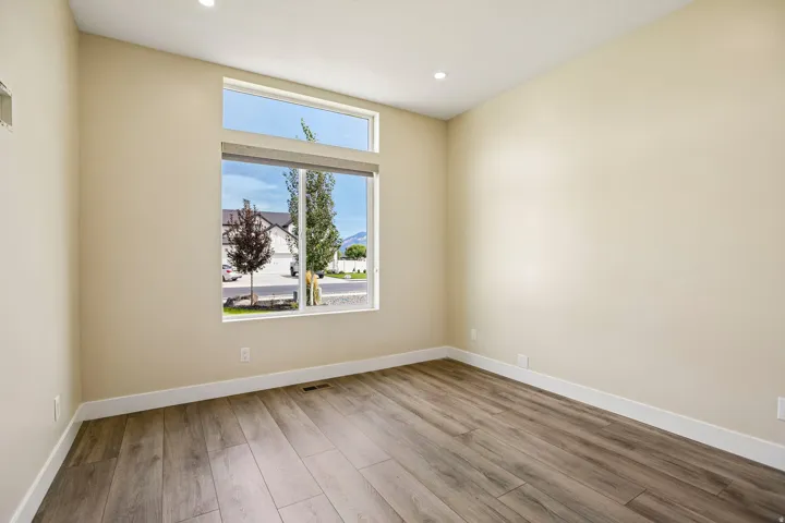 Expansive window arrangement with transom, wood-finish flooring, recessed lighting, and neutral wall tones