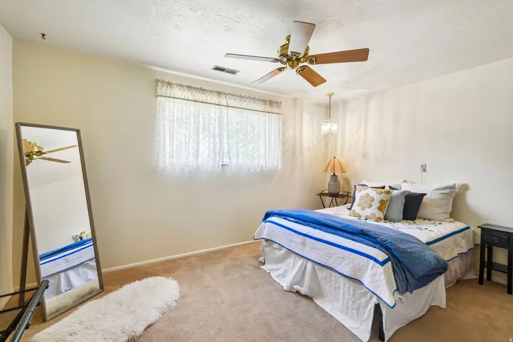 Ceiling fan with wood-finish blades, recessed lighting, and wall-to-wall carpeting