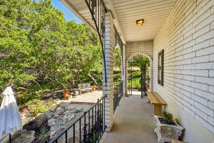 White brick exterior with a covered porch featuring decorative metal railing