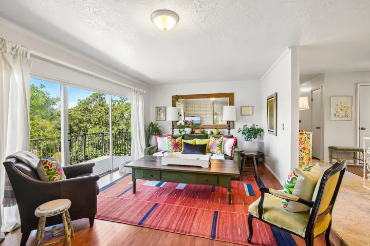 Hardwood flooring throughout, with a sliding glass door opening to a private balcony