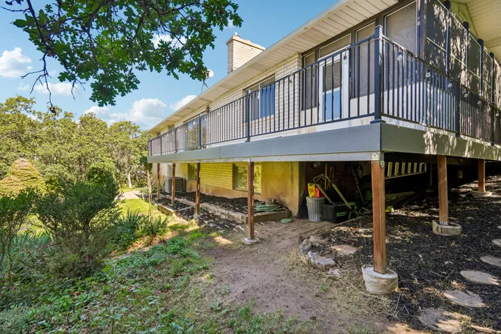 Elevated composite decking with black metal railing, featuring a screened-in section and access to the interior