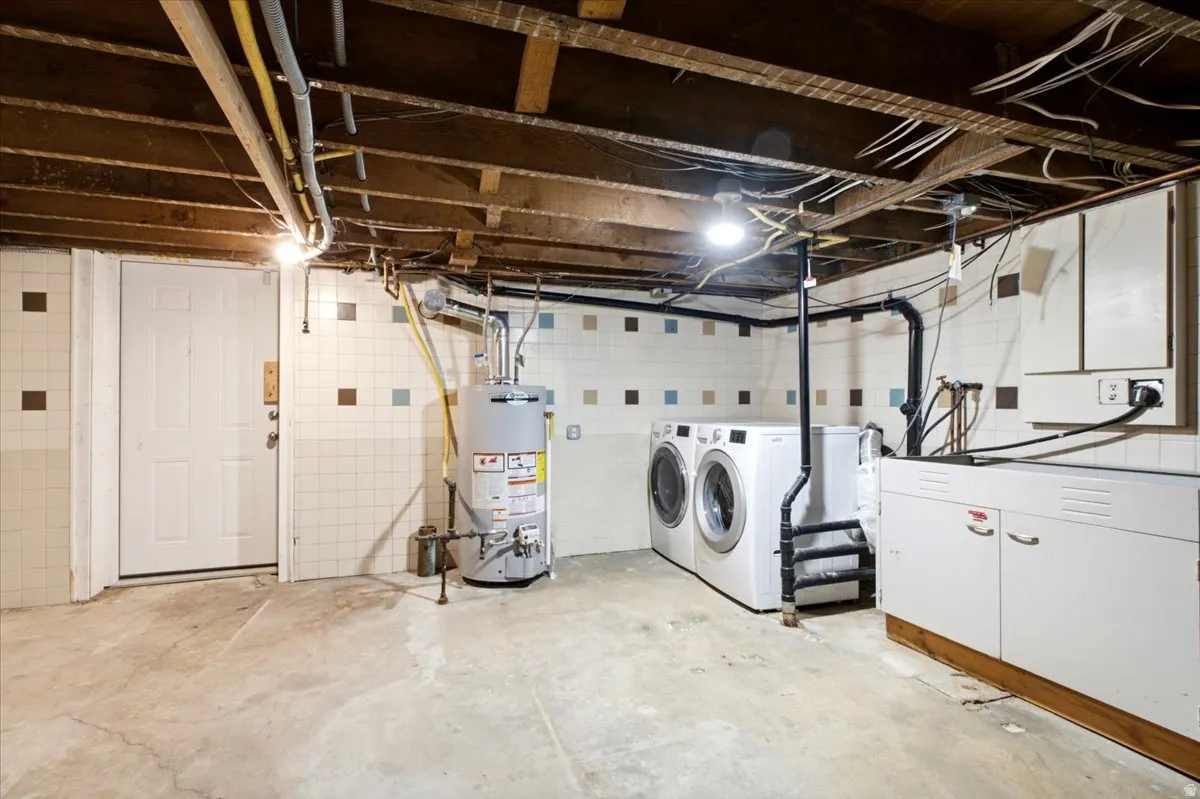 Laundry area with white tile walls featuring accent squares