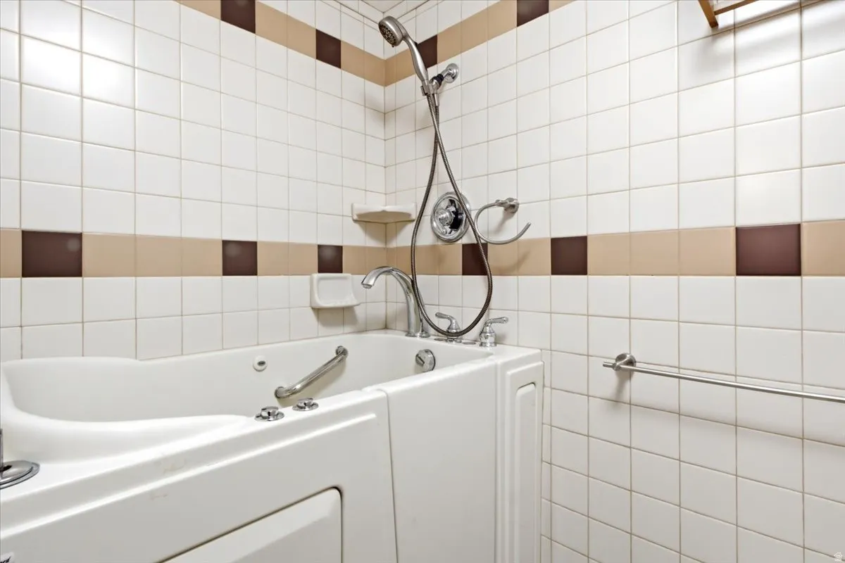 Walk-in tub with grab bar and chrome fixtures