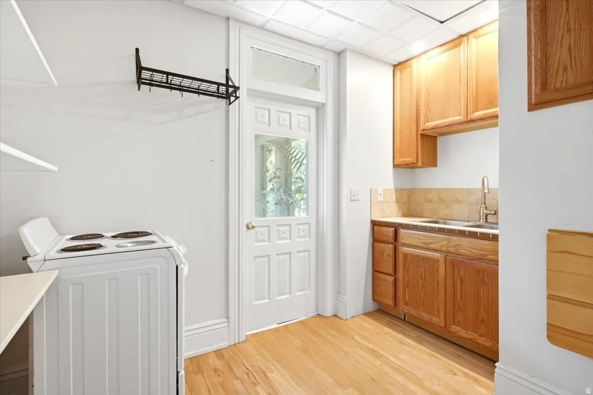 south apt.  Hardwood flooring, wood cabinetry, tile backsplash, built-in sink, and a paneled door with glass insert