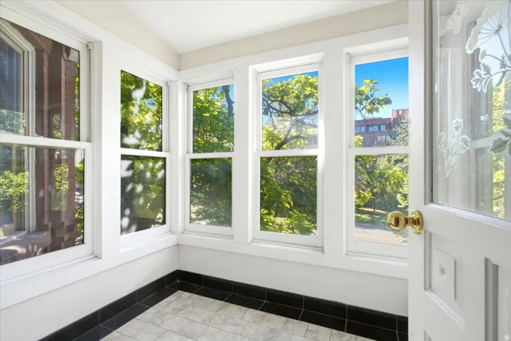 sun porch Multiple windows, white trim, black tile baseboard, patterned floor tiles, white door with decorative glass