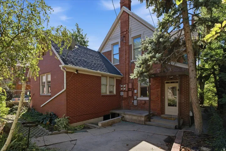 Charming brick Colonial featuring a distinctive peaked roofline and gabled architecture