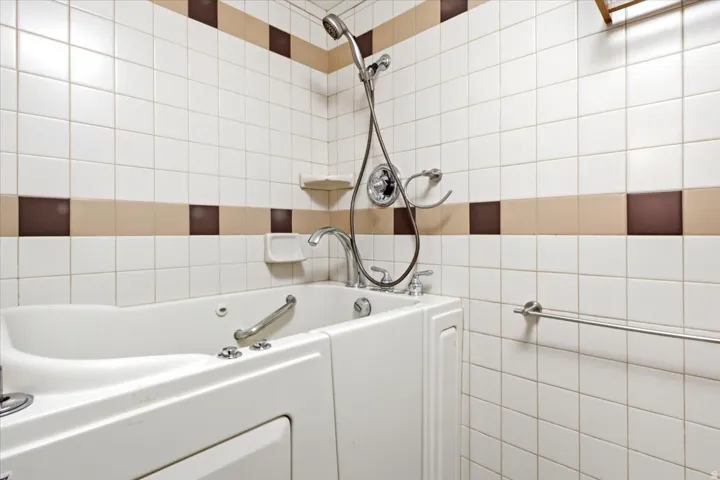 Walk-in tub with grab bar and chrome fixtures