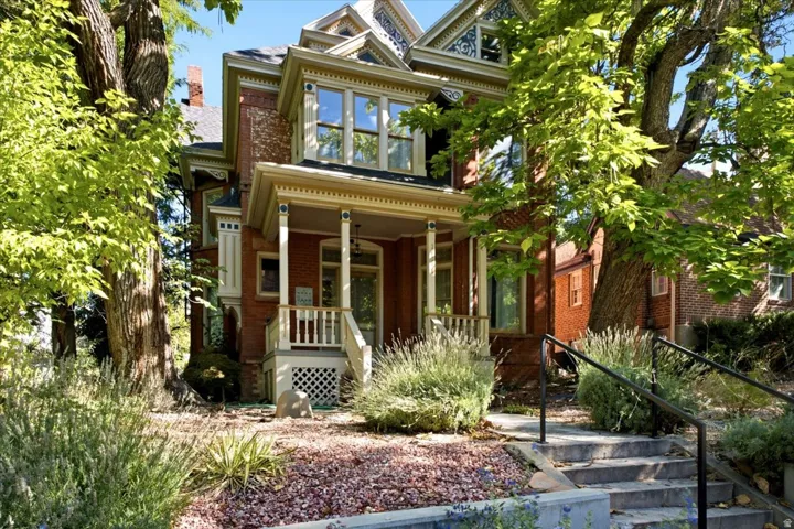 Brick exterior, detailed trim work, covered front porch, stone steps with handrails, established landscaping