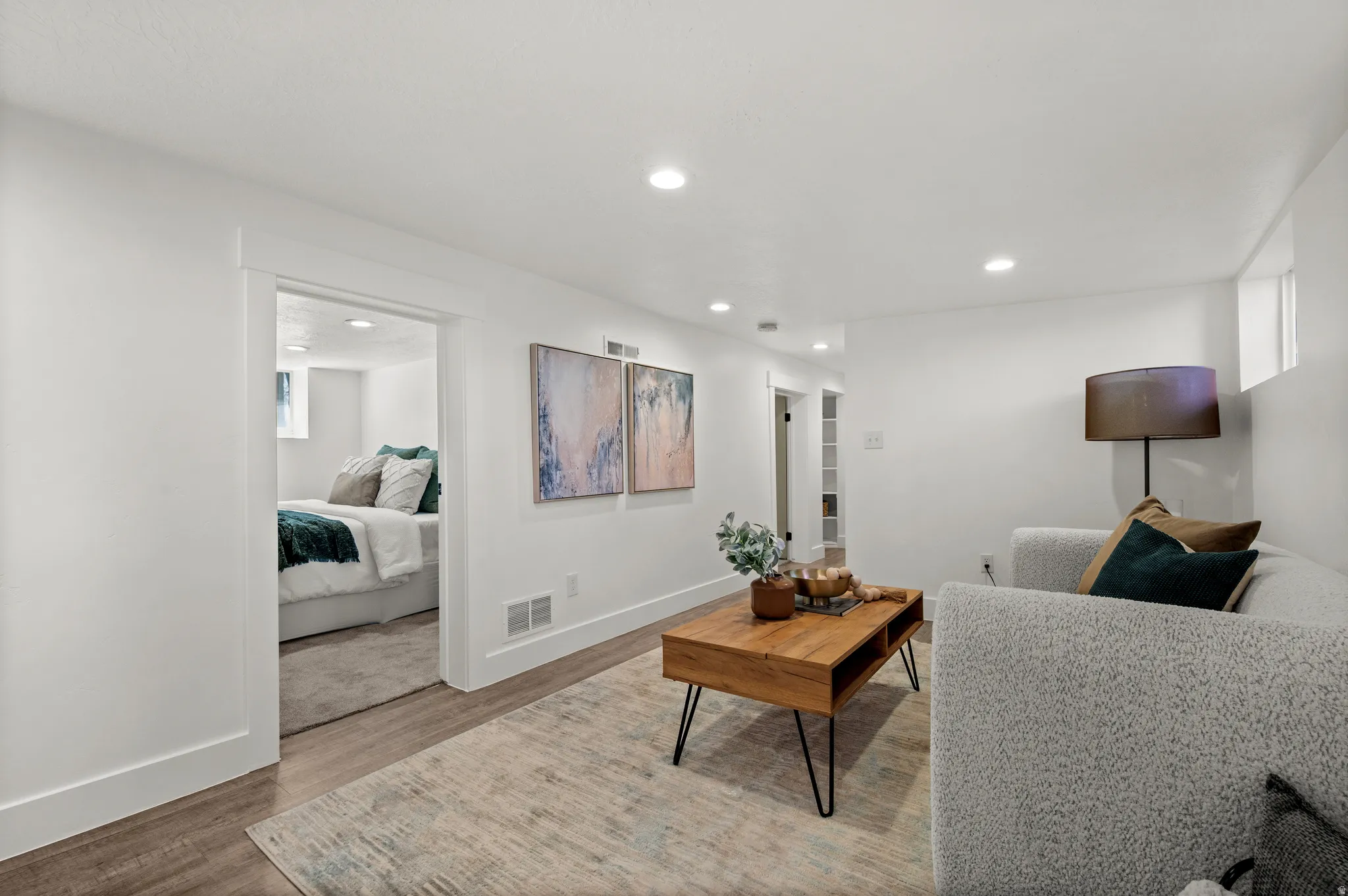 Recessed lighting illuminating the open-concept living area with wood-finish flooring