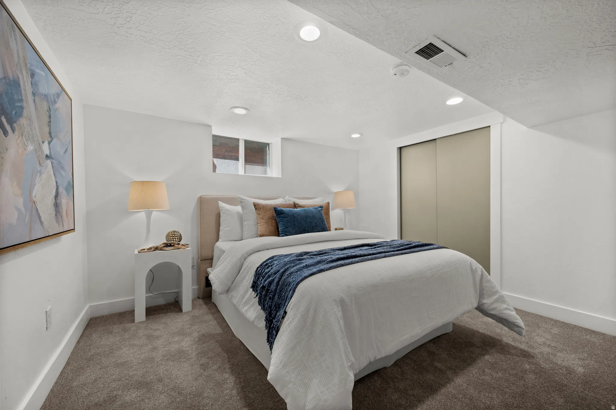 Plush carpeting, recessed lighting, and a window for natural light