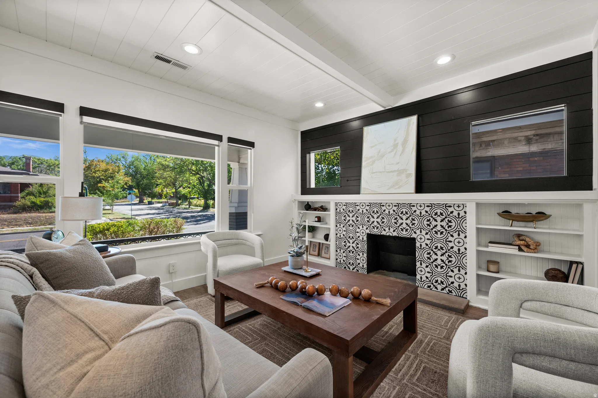 Living area featuring a fireplace with patterned tile surround, built-in shelving, white shiplap ceiling, recessed lighting, and large windows