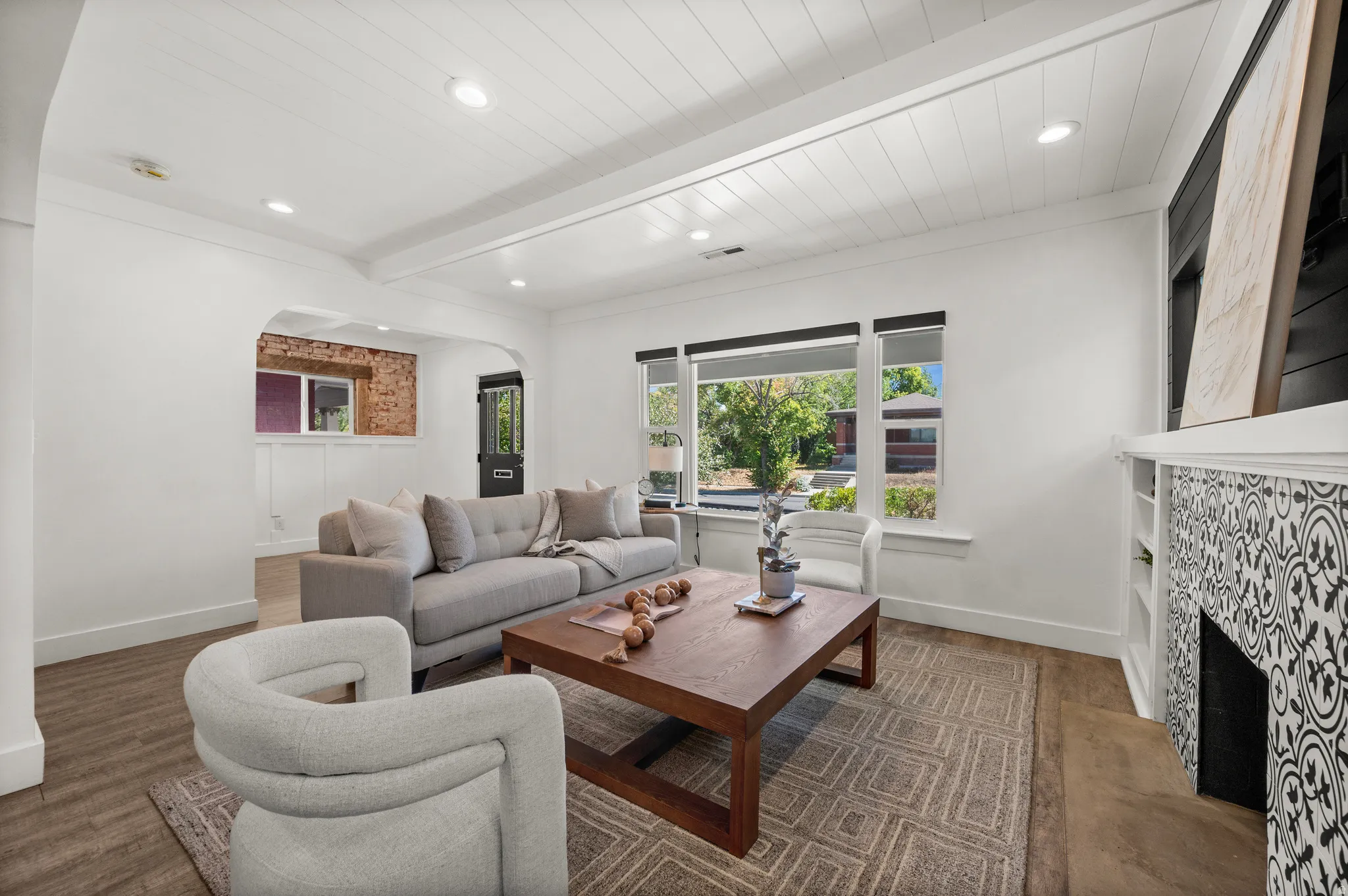 Recessed lighting illuminates a shiplap ceiling with exposed beams