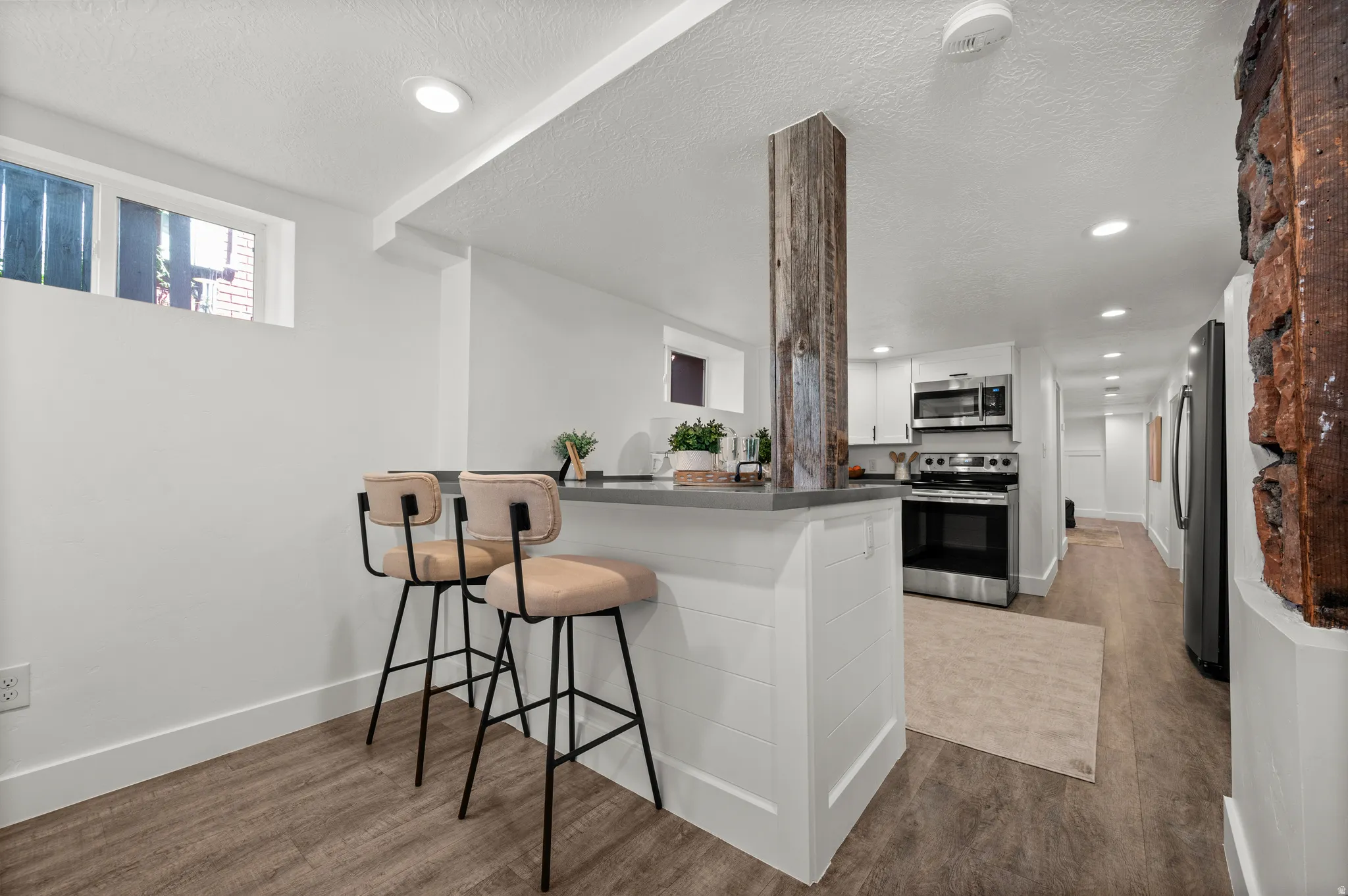Kitchenette featuring stainless steel appliances, white cabinetry, and a countertop with bar seating
